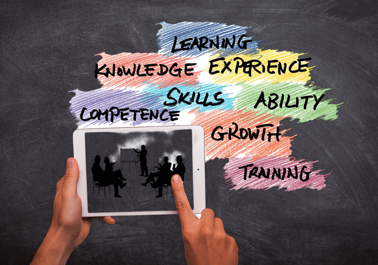 Psychologisches Coaching Hand hält ein Tablet, umgeben von Begriffen zu Lernen, Kompetenz und Wachstum auf schwarzem Hintergrund.