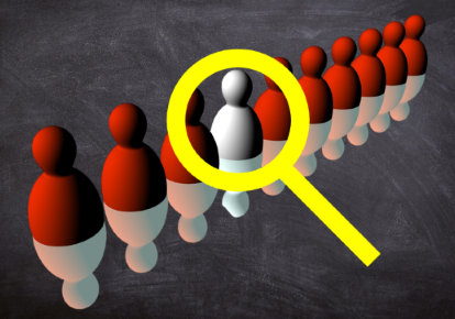 Mitarbeitende Weiße Figur in einer Reihe roter Figuren, vergrößert durch eine Lupe.