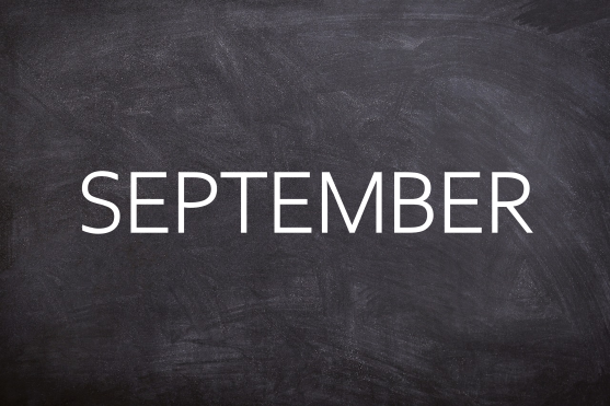 Oktober Schwarze Tafel mit dem Wort "OKTOBER" in großen, weißen Buchstaben.