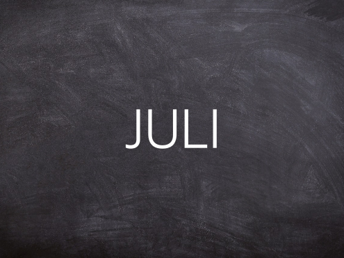 Tafel mit dem Wort "JULI" in großer, heller Schrift.